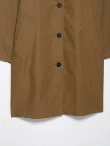 Detail of single-breasted brown trench coat with twill texture and black button accents