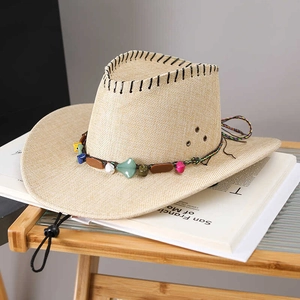 Détail du chapeau de paille à large bord avec bande de pierres ethniques et mentonnière