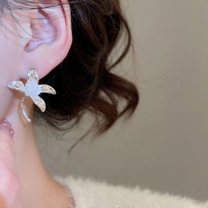 Detailansicht silberner Blumenohrstecker mit einer weißen matten fünfblättrigen Blüte