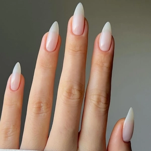 Detailed view of long almond press-on nails with natural creamy nude ombre gradient