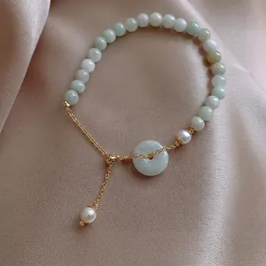 Elegant Chinese style pearl and jade bead bracelet set on premium champagne satin background