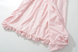 Détail de la robe licou rose avec ourlet à volants superposés et texture plissée
