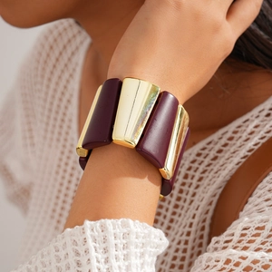 Close-up of geometric acrylic and gold alloy elastic bracelet worn on a female wrist