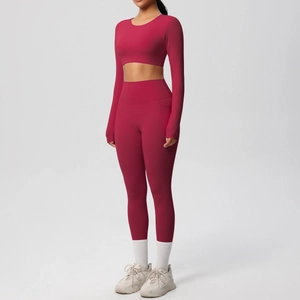 Detail of high-waist yoga leggings with side pockets and long sleeve crop top in burgundy