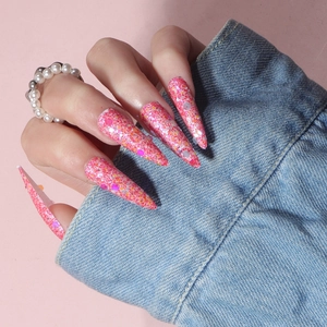 Detail of pink stiletto press-on nails with sparkling sequins and glitter finish