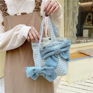 Detail of blue plaid lunch bag with denim bows and secure metal snap closure