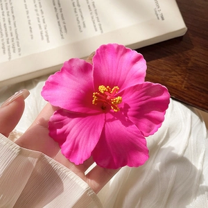 Macro detail of hibiscus flower hair clip with realistic pink petals and yellow stamen