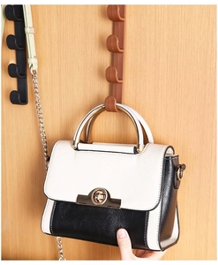 Detailed view of brown vertical over-the-door organizer rack with four storage hooks