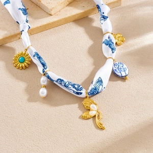 Vintage floral ribbon necklace with golden sunflower, turquoise, and pearl charms