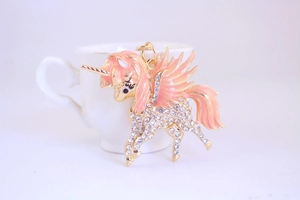 Détail du porte-clés licorne en émail rose avec strass brillants sur une tasse