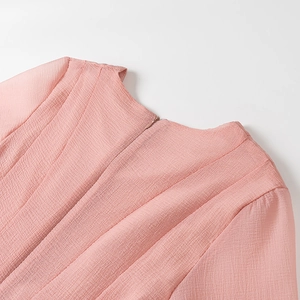 Close-up of invisible back zipper and textured pleated pink fabric on the dress