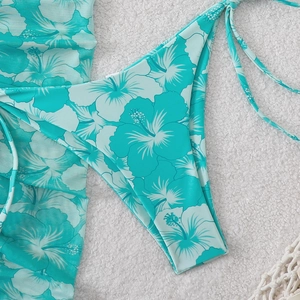 Detail of cyan tropical hibiscus print bikini bottoms and matching light beach cover-up