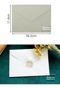 Detail view of sage green and white envelopes with wax seal and dried flower accents