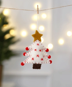 Close-up of white felt Christmas tree ornament with red accents and a yellow star