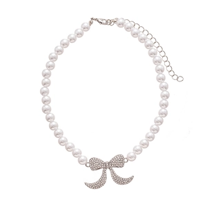 Collana di perle finte vintage con pendente a fiocco incastonato di diamanti su sfondo bianco