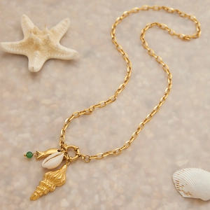Détail d'un collier en acier doré avec pendentifs coquillages et étoile de mer chic