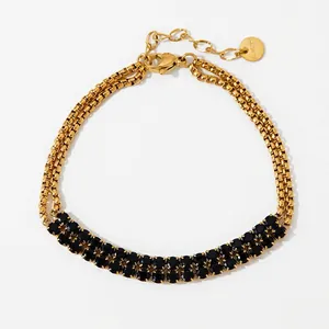 Detail of double-layer gold stainless steel bracelet with black faceted gemstones