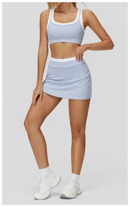 Detail view of light blue sports bra and high-waisted skirt with white contrast trim