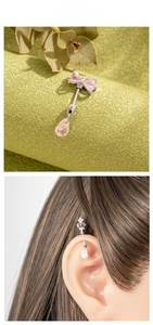 Detail of pink crystal bow cartilage piercing stud with water drop pendant