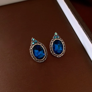 Détails macro des boucles d'oreilles ovales vintage avec pierres bleues et bronze