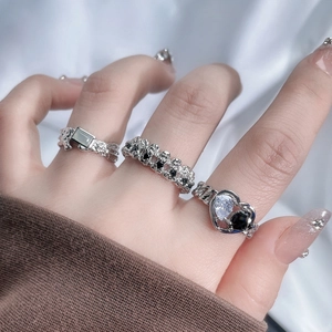 Detailed view of silver stackable rings with skull, heart, and square zircon designs