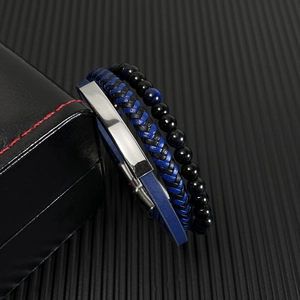 Close-up of multilayer braided leather bracelets with glass beads on textured black background