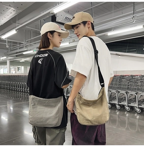 Detail view of large capacity canvas crossbody bags in dark grey and khaki on models