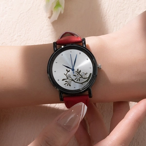 Montre quartz femme élégante avec bracelet cuir rouge et cadran floral portée au poignet