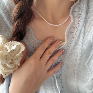 Close-up of elegant white pearl beaded necklace on neck with vintage lace detail