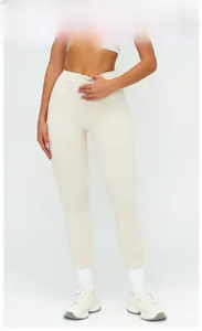 Detail of cross high-waisted yoga leggings in oatmeal apricot with white stitching