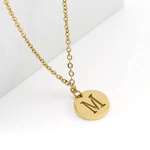 Close-up of 18K gold plated stainless steel necklace with hollow round M letter pendant