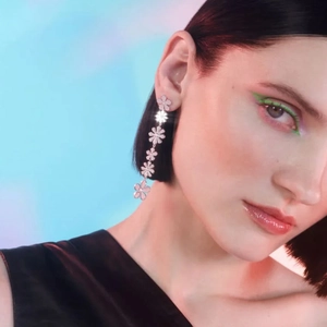 Boucles d'oreilles asymétriques marguerite en acier 18k avec pampilles fleurs sur mannequin