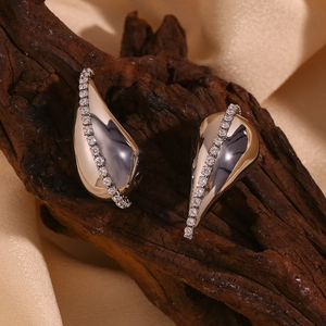 Détail macro de boucles d'oreilles gouttes argentées avec zircons sur socle en bois