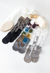 Three pairs of sheer mesh crew socks with geometric patterns and artistic prints