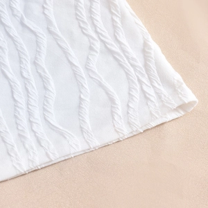 Macro detail of white textured seersucker fabric with wavy stripe pattern on dress