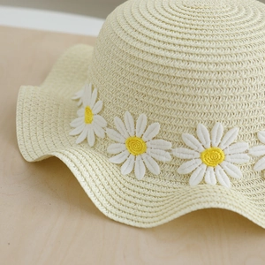 Girl's beige straw sun hat with daisy embroidery and wavy brim for summer beach travel