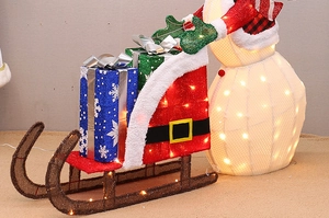 Détail d'un bonhomme de neige LED lumineux et traîneau rouge avec boîtes cadeaux