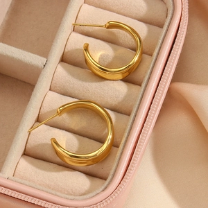 Macro shot of 18K gold plated C-shaped earrings inside a pink velvet jewelry box