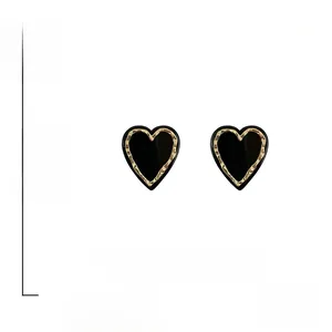 Detail view of heart-shaped acrylic earrings with gold hammered edges and S925 silver pins