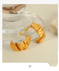 Detail of 18K gold plated stainless steel earrings with textured croissant wave pattern
