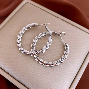 Macro shot of silver twisted hoop earrings with a high-shine metallic texture