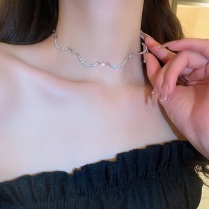 Dettaglio dell'elegante girocollo ondulato con zirconi lucenti sul collo della modella
