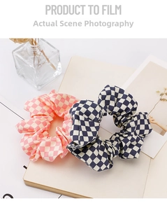 Detail shot of two plaid scrunchies in pink and navy blue patterns on a notebook