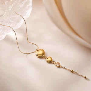 Elegant gold heart pendant necklace with clear crystals on a minimalist background