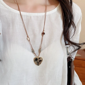 Close-up of heart resin leopard pendant necklace with tiger eye beads and wax cord