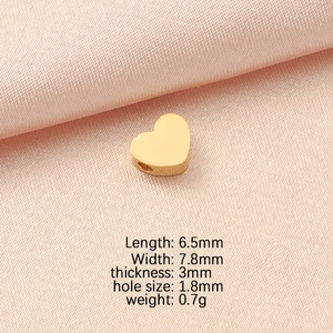 Détail macro de perles en forme de cœur dorées en acier inoxydable pour bijoux DIY