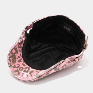 Detail view of pink leopard newsboy cap showing 100% cotton lining and metal button