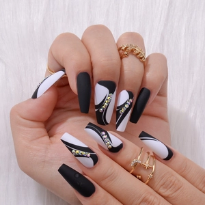 Detail of long coffin press-on nails with black white abstract lines and rhinestones