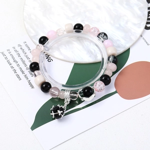 Detailed view of DIY bracelet featuring pink and black beads with silver metal pendant