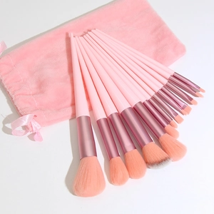 12-piece pink makeup brush set with synthetic bristles and a velvet drawstring pouch